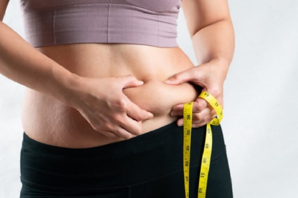 Ilustrasi perempuan mengukur lemak perut/Freepik