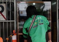 Pengemudi Gojek mengambil pesanan makanan di Jakarta, Indonesia, Selasa (5/1/2021)./Bloomberg-Dimas Ardian
