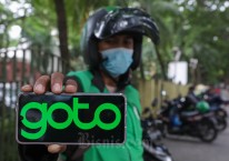 Pengemudi ojek online (ojol) menunjukan logo GoTo di Jakarta, Rabu (26/10/2022). Bisnis/Himawan L Nugraha
