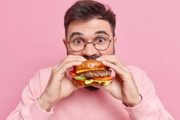 Ilustrasi pria berusia 40 tahun memakan hamburger atau fast food/Freepik