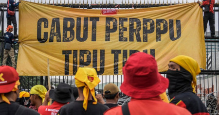 Pengunjuk rasa membentangkan spanduk saat berunjuk rasa di depan Gedung DPR, Senayan, Jakarta, Selasa (14/3/2023). Unjuk rasa yang diikuti serikat buruh, mahasiswa, dan petani itu menuntut pemerintah untuk segera mencabut Peraturan Pemerintah Pengganti Undang-Undang (Perppu) Nomor 2 Tahun 2022 tentang Cipta Kerja. ANTARA FOTO/Galih Pradipta/tom.