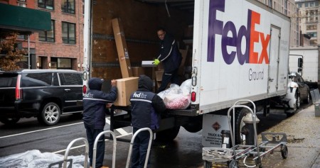 Pekerja FedEx melakukan bongkar muat barang di New York/ Bloomberg - Michael Nagle
