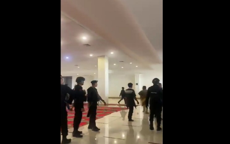 Tangkapan layar video personel kepolisian memasuki area Masjid Raya Sumatra Barat dengan mengenakan sepatu - Twitter