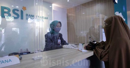 Karyawan melanyani nasabahyang melakukan transaksi di PT Bank Syariah Indonesia KC Jakarta Barat, Kebon Jeruk, Jakarta, Senin (1/2/2021). Bisnis