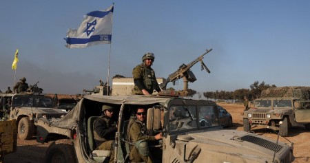 Tentara Israel duduk di dalam kendaraan militer, di tengah konflik yang sedang berlangsung antara Israel dan kelompok Islam Palestina Hamas, dekat perbatasan dengan Gaza, di Israel selatan, 18 Desember 2023. REUTERS/Ronen Zvulun