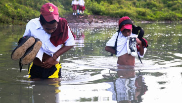 Siswa Menyeberangi Sungai Untuk Berangkat Sekolah