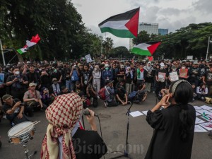 Massa yang tergabung dalam Koalisi Musisi untuk Gaza melakukan aksi di depan Kedutaan Besar Amerika Serikat di Jakarta, Jumat (19/4/2024). Bisnis/Fanny Kusumawardhani