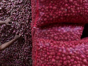 Pedagang mengupas kulit bawang merah yang akan dijual di Pusat Pasar, Medan, Sumatera Utara, Rabu (24/4/2024).