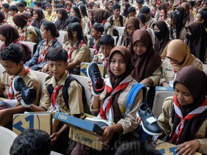 Sejumlah siswa menunjukkan sepatu yang dibagikan secara gratis di aula SMK N 8 Solo, Jawa Tengah, Jumat (26/4/2024).
