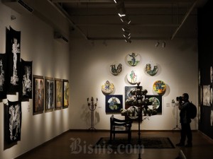 Pengunjung mengamati karya seni rupa pada pameran tunggal Butet Kartaredjasa di Galeri Nasional, Jakarta, Jumat (26/4/2024).