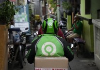 Pengemudi atau driver Gojek mengantarkan paket pesanan dari platform Tokopedia di Jakarta, Jumat (8/4/2022). - Bloomberg/Dimas Ardian