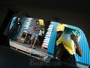 Pekerja mengangkut beras ke dalam mobil di gudang Bulog Kendari, Kendari, Sulawesi Tenggara, Minggu (5/5/2024).