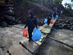 Petugas melewati jembatan darurat membawa bantuan logistik untuk korban banjir bandang di Nagari Sungai Jambu, Tanah Datar, Sumatra Barat, Jumat (17/5/2024). Antara/Iggoy el Fitra