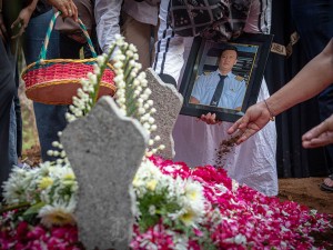 Seorang kerabat membawa foto almarhum Kapten Pilot Pulu Darmawan saat prosesi pemakamannya di TPU Desa Duren, Semarang, Jawa Tengah, Senin (20/5/2024).