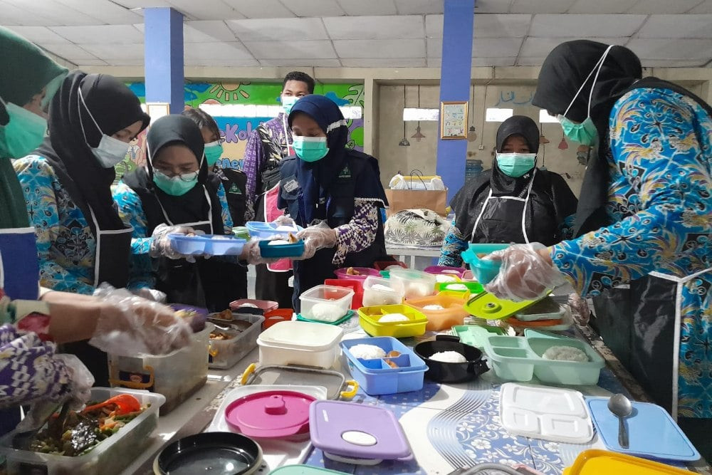 Petugas kantin tengah menyiapkan makan bergizi gratis bagi anak sekolah SMPN 2 Curug, Tangerang, Kamis (29/2/2024). JIBI/Annasa Rizki Kamalina