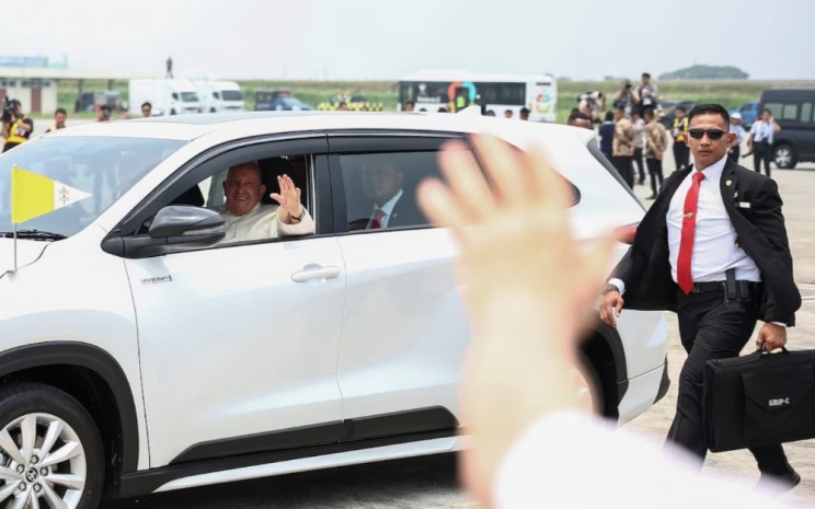 Paus Fransiskus melambaikan tangan dari dalam mobil setelah tiba di Bandara Internasional Soekarno-Hatta di Tangerang, Indonesia, 3 September 2024. REUTERS - Guglielmo Mangiapane