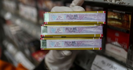 Pedagang memegang bungkus rokok bercukai di Jakarta. Bisnis/Eusebio Chrysnamurti
