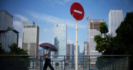 Seorang pria berjalan melewati rambu Dilarang Masuk di dekat kantor pusat China Evergrande Group di Shenzhen, provinsi Guangdong, China 26 September 2021./Reuters