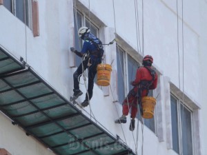 Pekerja melakukan perawatan rutin disalah satu gedung bertingkat yang ada di Makassar, Sulawesi Selatan