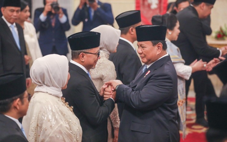 Presiden Prabowo Subianto (kanan) berjabat tangan dengan Menteri Koordinator Pangan Zulkifli Hasan seusai pelantikan jajaran menteri Kabinet Merah Putih di Istana Negara, Jakarta, Senin (21/10/2024).  Bisnis - Himawan L Nugraha