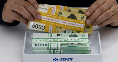 Uang won pecahan 50.000 dan 100.000 dipotret di Seoul, Korea Selatan pada Kamis (18/4/2024). / Bloomberg-SeongJoon Cho