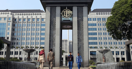 Karyawan melintas didekat logo Bank Indonesia (BI) di Jakarta, belum lama ini. Bisnis/Abdullah Azzam