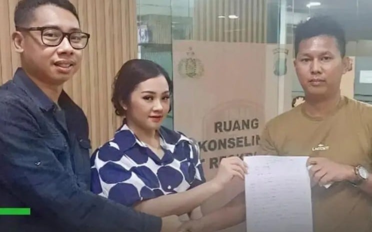 Kompol Bambang Surya Wiharga (kacamata) saat membuat surat damai dengan RF (kanan) sopir taksi online setelah insiden pemukulan. (Foto:IG - @merekamjakarta)