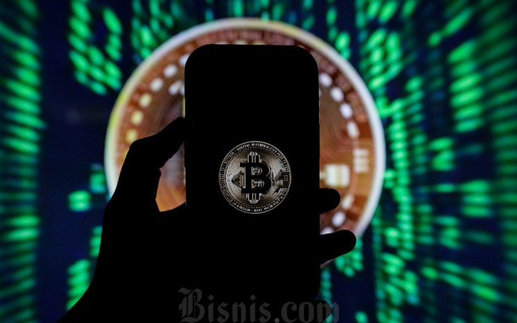 Warga beraktivitas di dekat logo Bitcoin di Jakarta, Selasa (15/10/2024). Bisnis - Fanny Kusumawardhani