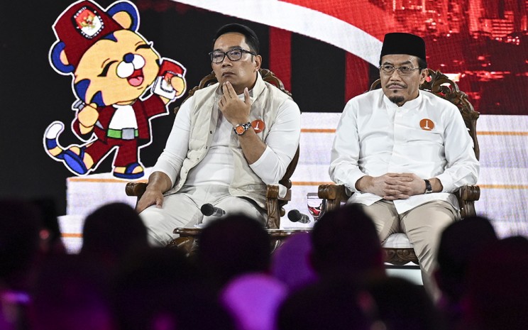 Pasangan calon Gubernur-Wakil Gubernur DKI Jakarta nomor urut satu Ridwan Kamil (kiri) dan Suswono (kanan) mengikuti debat pertama pasangan Calon Gubernur dan Wakil Gubernur DKI Jakarta tahun 2024 di JIExpo Kemayoran, Jakarta, Minggu (6/10/2024). ANTARA FOTO - Aprillio Akbar