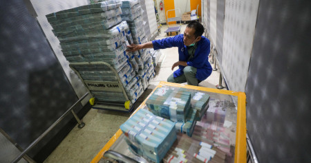 Pegawai merapikan uang rupiah di cash center Bank Mandiri di Jakarta.