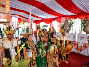 Petugas mengenakan kostum kerajaan membuka kotak suara yang masih di segel di TPS 03 Desa Sawahkulon, Kecamatan Pasawahan, Kabupaten Purwakarta, Jawa Barat