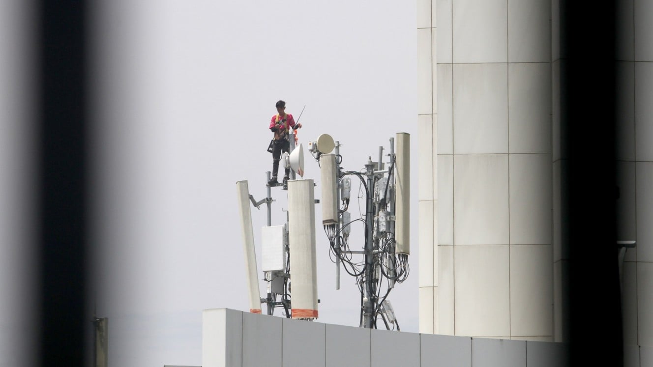 Teknisi mengerjakan perawatan rutin prangkat di tower base transceiver station (BTS) di Makassar, Sulawesi Selatan, Senin (3/3/2025)./Bisnis/Paulus Tandi Bone