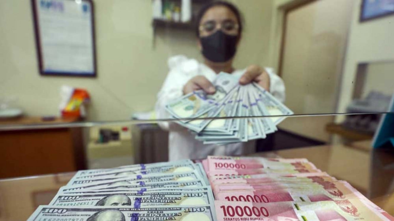 Employees show rupiah and US dollar currency at the Dolar Asia Money Changer, Jakarta. Health issuers like KLBF and PRDA face rising costs due to rupiah depreciation and import dependence. Bisnis/Himawan L Nugraha