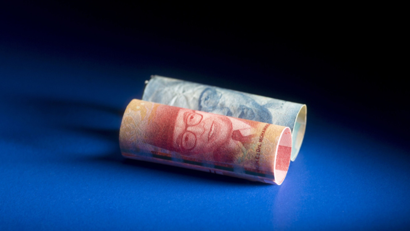Uang lembar pecahan Rp100.000 dan Rp50.000. / Bloomberg-Brent Lewin
