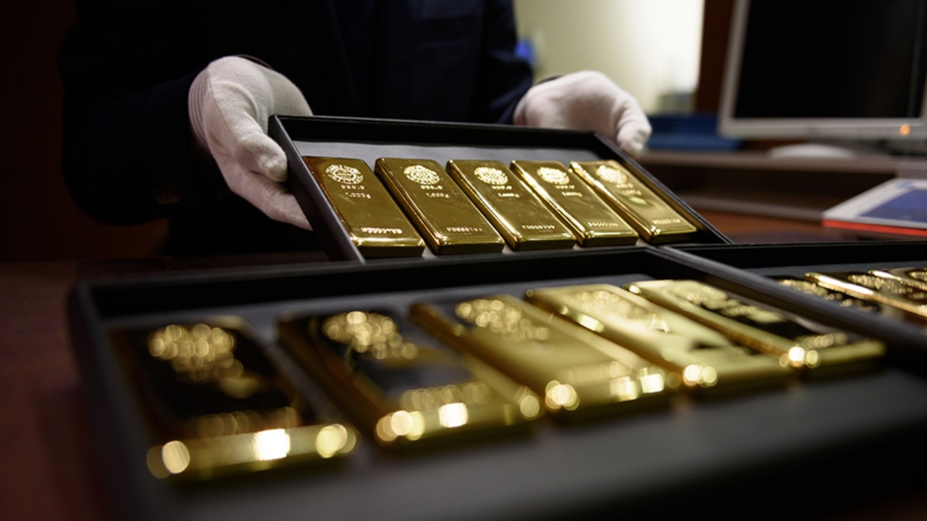 Seorang karyawan memamerkan emas batangan seberat satu kilogram untuk difoto di toko Tanaka Holdings Co. di Tokyo, Jepang. Bloomberg/Akio Kon