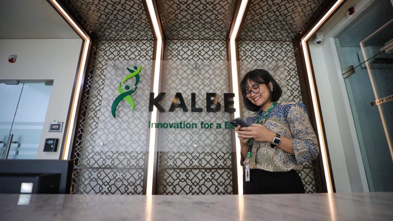 Karyawati beraktivitas di dekat logo Kalbe Farma di Jakarta, Senin (15/7/2024). /Bisnis/Arief Hermawan P