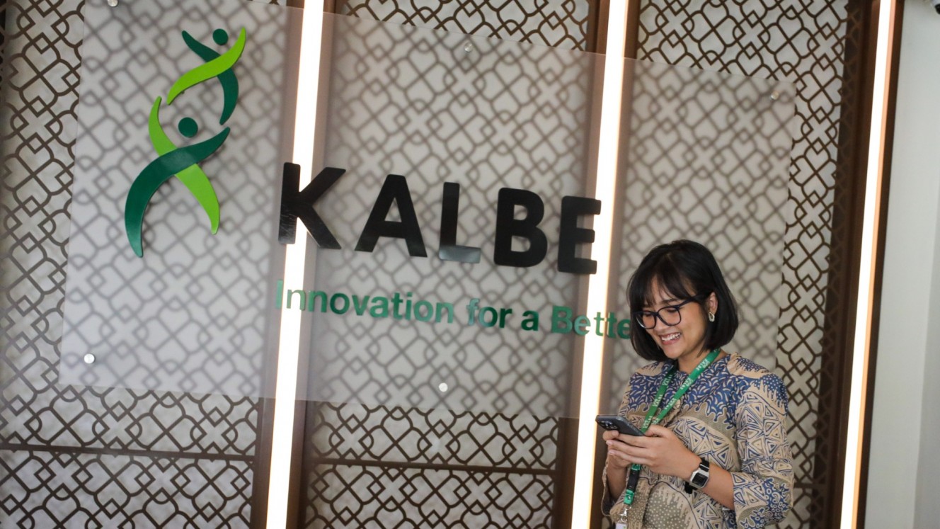 Karyawati beraktivitas di dekat logo Kalbe Farma di Jakarta, Senin (15/7/2024). PT Kalbe Farma Tbk. (KLBF) menargetkan laba bersih tahun ini dapat tumbuh hingga 15% seiring dengan pertumbuhan penjualan dan strategi memanfaatkan peluang reformasi sektor kesehatan melalui berbagai inisiatif bisnis. JIBI/Bisnis/Arief Hermawan P