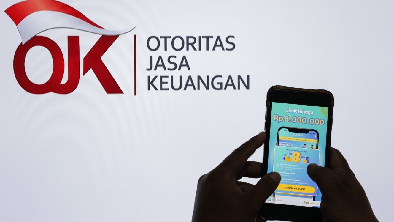 Warga mencari informasi tentang pinjaman online di Jakarta, Senin (12/8/2024)/ Bisnis/Fanny Kusumawardhani