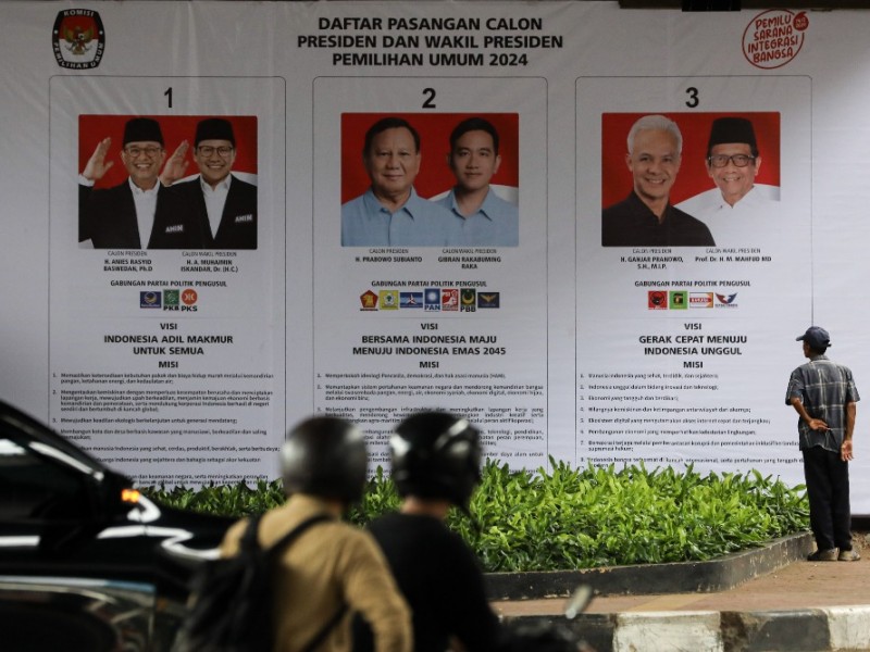 SOSIALISASI PILPRES 2024 Warga mengamati baliho bertema Calon Presiden-Calon Wakil Presiden (Capres-Cawapres) yang maju pada Pemilihan Presiden (Pilpres) 2024 di Jakarta, Senin (8/1/2024). JIBI/Bisnis/Arief Hermawan P 