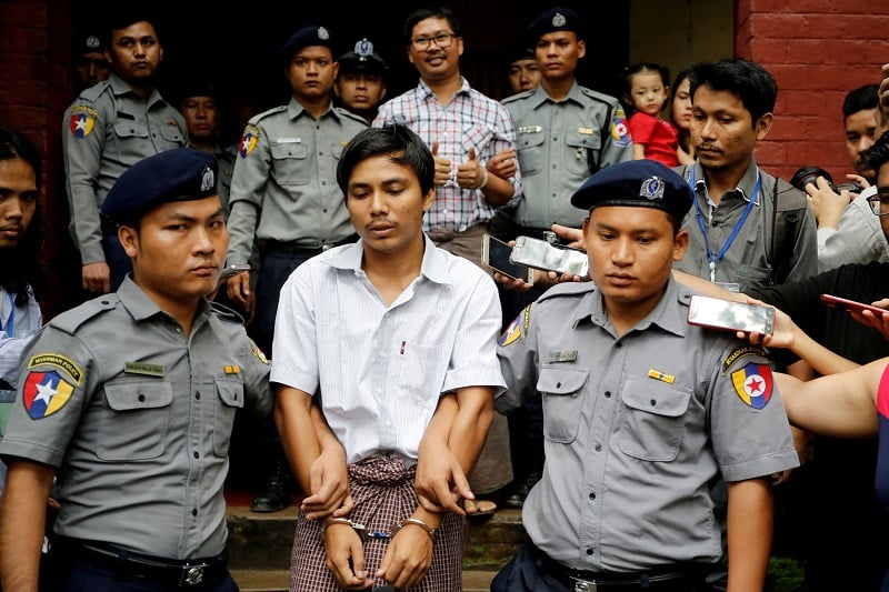 Wartawan Reuters yang ditahan, Kyaw Soe Oo dan Wa Lone dikawal oleh polisi ketika mereka pergi setelah sidang di Yangon, Myanmar, 20 Agustus 2018/REUTERS-Ann Wang