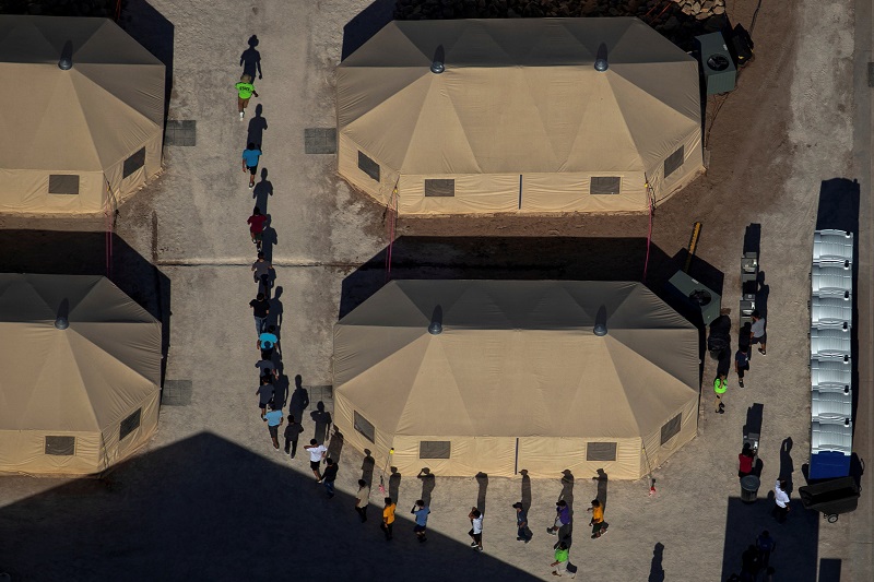 Anak-anak migran berbaris dalam satu barisan antar tenda di fasilitas penahanan di dekat perbatasan Meksiko di Tornillo, Texas, 18 Juni 2018/Reuters-Mike Blake