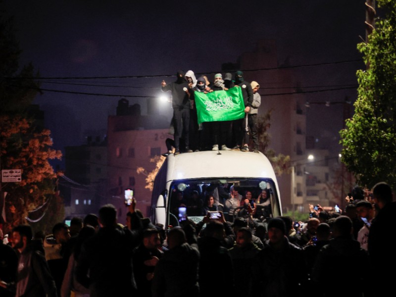 Orang-orang yang membawa bendera berdiri di atas sebuah bus ketika mereka bereaksi terhadap kedatangan sebuah bus yang membawa warga Palestina yang dibebaskan dari penjara-penjara Israel sebagai bagian dari pertukaran sandera-tahanan dan kesepakatan gencatan senjata antara Hamas dan Israel, di Ramallah di kawasan yang diduduki Israel. Tepi Barat. 20 Januari 2025. REUTERS/Mussa Qawasma