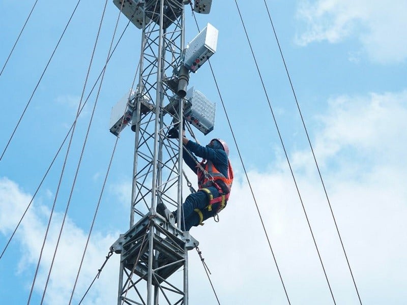 Pekerja memperbaiki menara Indosat