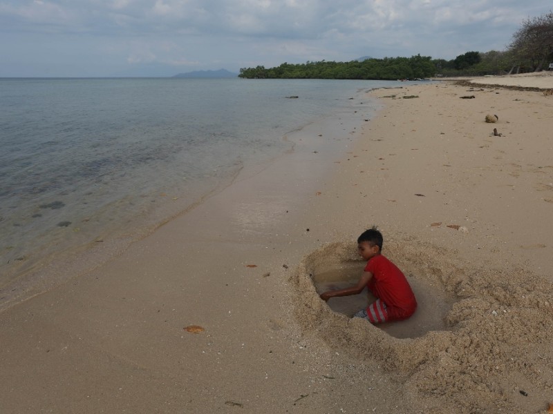 Seorang anak bermain pasir di Pantai Pasi Putih Atapupu, Belu, Nusa Tenggara Timur (NTT), Selasa (28/11/2023).