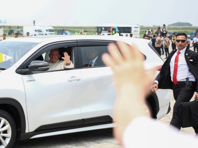 Paus Fransiskus melambaikan tangan dari dalam mobil setelah tiba di Bandara Internasional Soekarno-Hatta, Tangerang pada Selasa (3/9/2024). / Reuters-Guglielmo Mangiapane