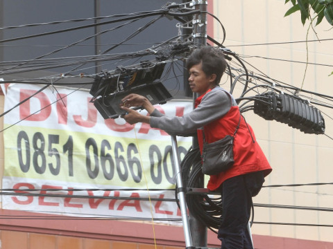 Petugas memperbaiki kabel serat optik