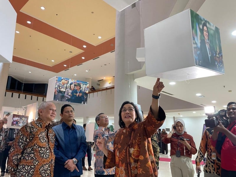 Menteri Keuangan Sri Mulyani Indrawati (kanan) bersama suaminya, Tonny Sumartono (kiri), serta Wakil Menteri Keuangan II Thomas Djiwandono dan Wakil Menteri Keuangan I Suahasil Nazara melihat foto-foto dalam acara peluncuran buku biografi Sri Mulyani berjudul 'No Limits, Reformasi dari Hati', Jumat (20/9/2024) di Jakarta. / Bisnis-Wibi Pangestu Pratama