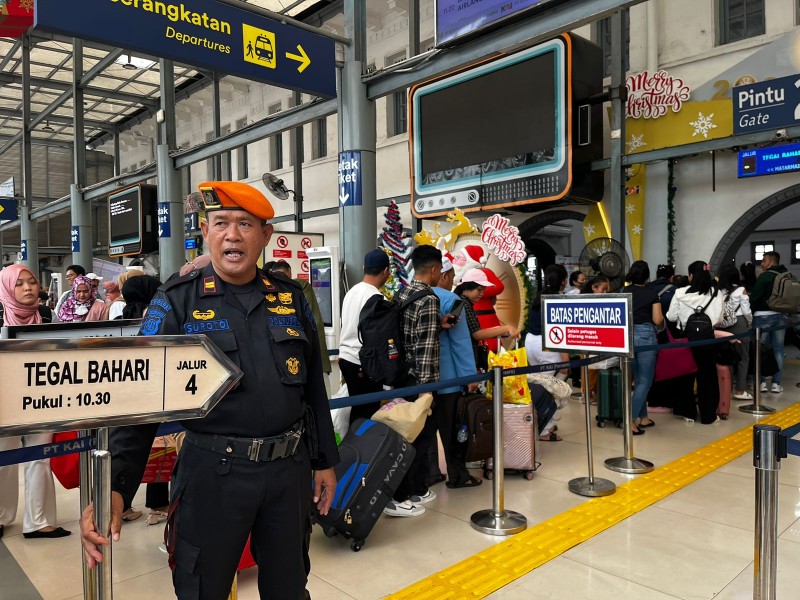 Petugas sedang menertibkan penumpang yang memadati Stasiun Senen