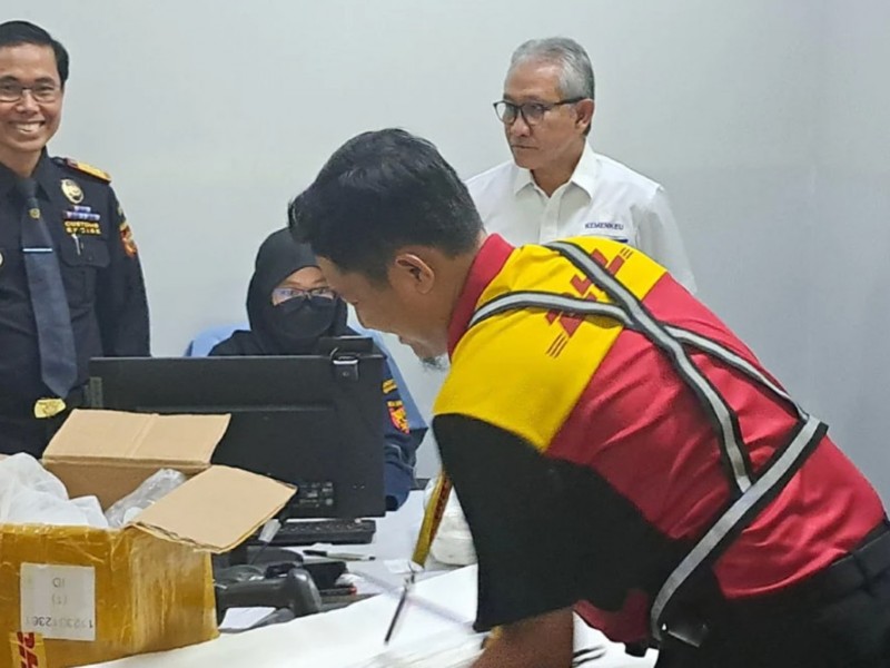 Dirjen Bea Cukai Askolani memamtau proses unboxing barang kiriman di Perusahaan Jasa Titipan (PJT) DHL Express dilakukan oleh petugas dari PJT didampingi petugas Bea Cukai./ BISNIS - Dwi Rachmawati