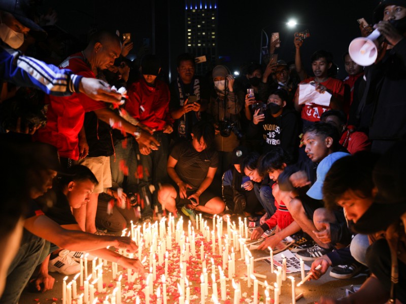 Sejumlah massa aksi pencinta sepak bola menggelar aksi tabur bunga dan 1000 lilin atas tragedi kematian suporter Arema di Stadion Utama Gelora Bung Karno, Jakarta, Minggu (2/10/2022). - Bisnis/Suselo Jati